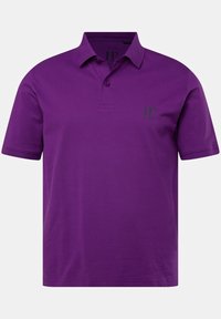 Fioletowa koszulka polo z gładkiego materiału, z kołnierzykiem, zapięciem na trzy guziki oraz małym zielonym logo "JP" na klatce piersiowej.