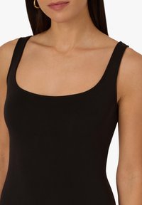 Top in tessuto nero aderente con scollatura quadrata, realizzato in materiale liscio ed elastico. Presenta spalline larghe e un design senza cuciture.