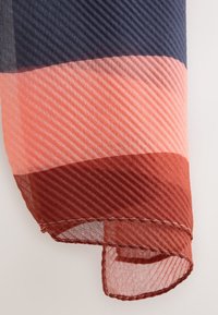 Bufanda ligera con rayas que presenta un degradado de colores azul marino, coral y óxido. Textura suave y transparente con bordes enrollados.