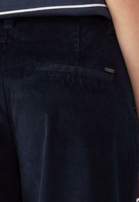 Marineblaue Cordhosen mit strukturiertem Muster, schmaler Passform und einer gesicherten Gesäßtasche mit einem kleinen Markenetikett.