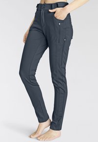 Tmavo šedé nohavice so slim fit strihom, prednými zipsovými vreckami a hladkým tkaninovým povrchom, so pásom a zapínaním na dva gombíky.