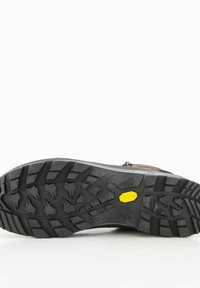 Vibram-Rubberlaufsohle mit tiefem Profil, schwarzer Farbe und gelbem Logo. Robuste Bauweise geeignet für unwegsames Gelände und Outdoor-Aktivitäten.