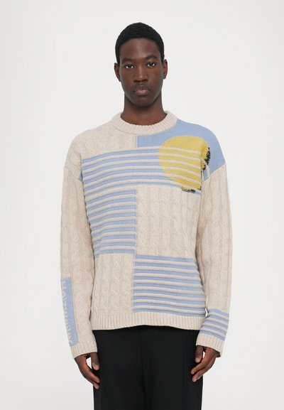 Sweter z dzianiny w beżowo-niebieski geometryczny wzór, z okrągłym dekoltem, teksturą warkocza i żółtym akcentem w designie.