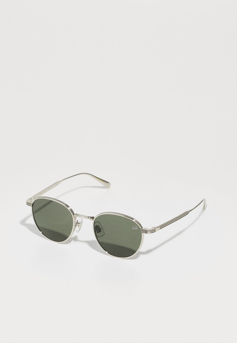 Óculos de sol metálicos com armação prateada e lentes verdes. Forma oval com detalhes texturizados nas hastes. Design leve.