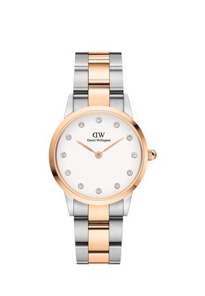 Stříbrné a růžově zlaté kovové hodinky s bílým ciferníkem, které mají diamantové indexy hodin, minimalistický design a leštěný povrch.