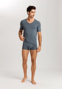 Grå V-hals kortärmad t-shirt som matchar med åtsittande boxerunderkläder, tillverkad av mjukt tyg med en slät textur.