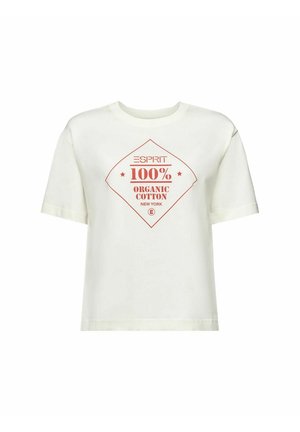 Person trägt ein weißes T-Shirt mit rotem Schriftzug "ESPRIT 100% Organic Cotton New York", blaue Jeans und einen gestreiften Pullover um die Taille gebunden.