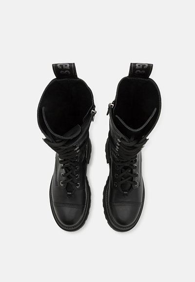 Black leather combat boots featuring a rounded toe, textured surface, and lace-up design with a pull tab at the top.