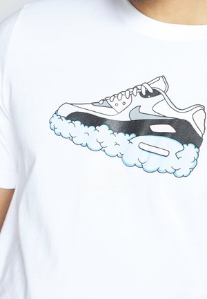 Grafik eines schwarz-weißen Sneakers mit wolkenähnlichen Blasen, die die Sohle bilden, auf einem weißen T-Shirt gedruckt.