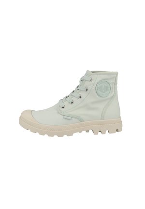 Bottes montantes en toile de couleur vert menthe clair, avec un capuchon en caoutchouc à l'avant, cinq œillets et une semelle beige robuste avec une texture antidérapante.