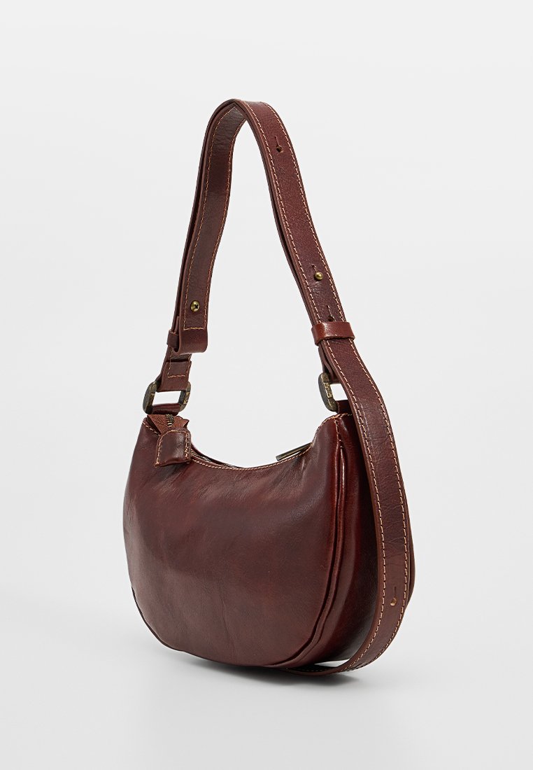 Brązowa skórzana torba na ramię o zakrzywionym kształcie, z regulowanym paskiem, subtelnymi detalami w postaci przeszyć oraz gładką teksturą.