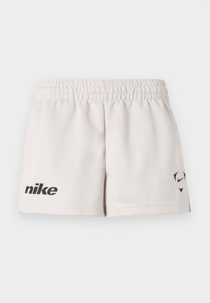 Άσπρα σορτς Nike με ελαστική μέση, μαύρο κείμενο "nike" στο αριστερό πόδι και μικρό μαύρο λογότυπο Swoosh με γεωμετρικά σχήματα στο δεξί πόδι.