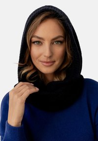 Granatowy szalik z kapturem wykonany z miękkiego, fakturowanego materiału, który dobrze przylega do szyi, z gładką podszewką i układającym się fasonem.