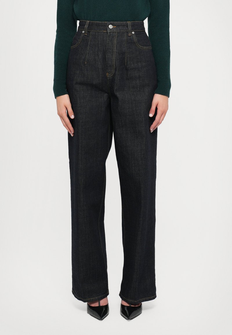 Donkerblauwe wijdvallende jeans van denim, met een hoge taille, contrasterende gele stiksels en een gesloten knop aan de voorkant.