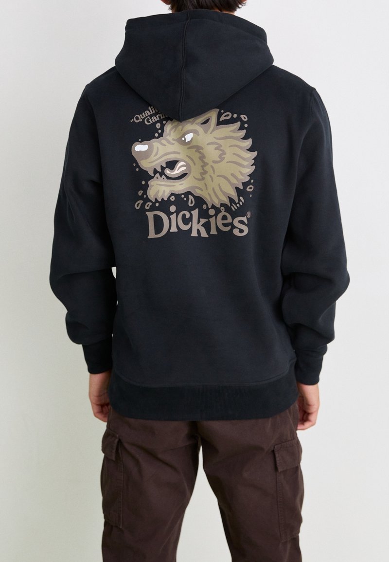 Sweat à capuche noir arborant un graphisme de loup aux couleurs beige et blanc. La marque "Dickies" est affichée en blanc en dessous.