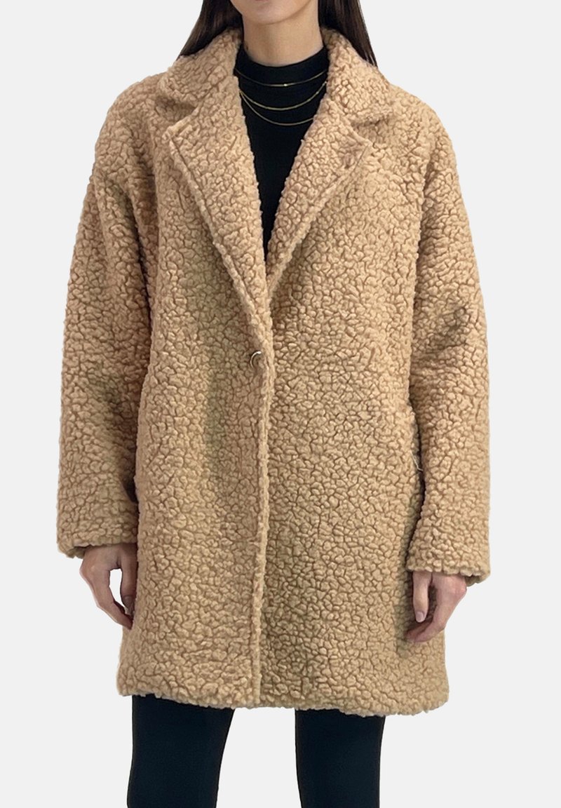 Beżowy, teksturowany płaszcz z imitacji futra z wyciętym kołnierzem, zapięciem na jeden guzik i dwoma bocznymi kieszeniami. Luźny fason z długimi rękawami.
