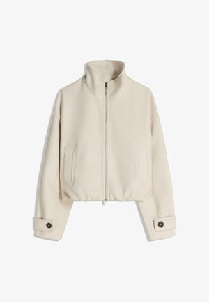 Kratka bež jakna od mekanog materijala, s visokim ovratnikom, prednjim patentnim zatvaračem i dva bočna džepa; rukavi s manžetama na kopčanje.