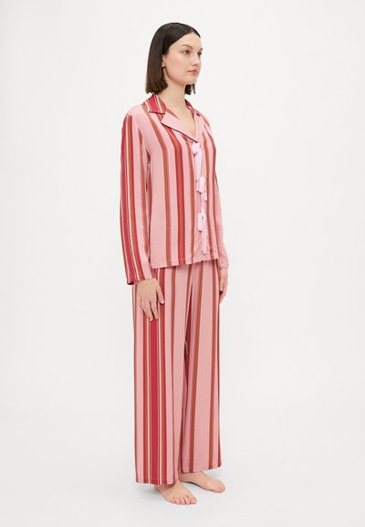 Gestreept roze pyjama set bestaande uit een overhemd met knopen en lange mouwen, en wijdvallende broek, gemaakt van zachte stof met een gladde textuur.