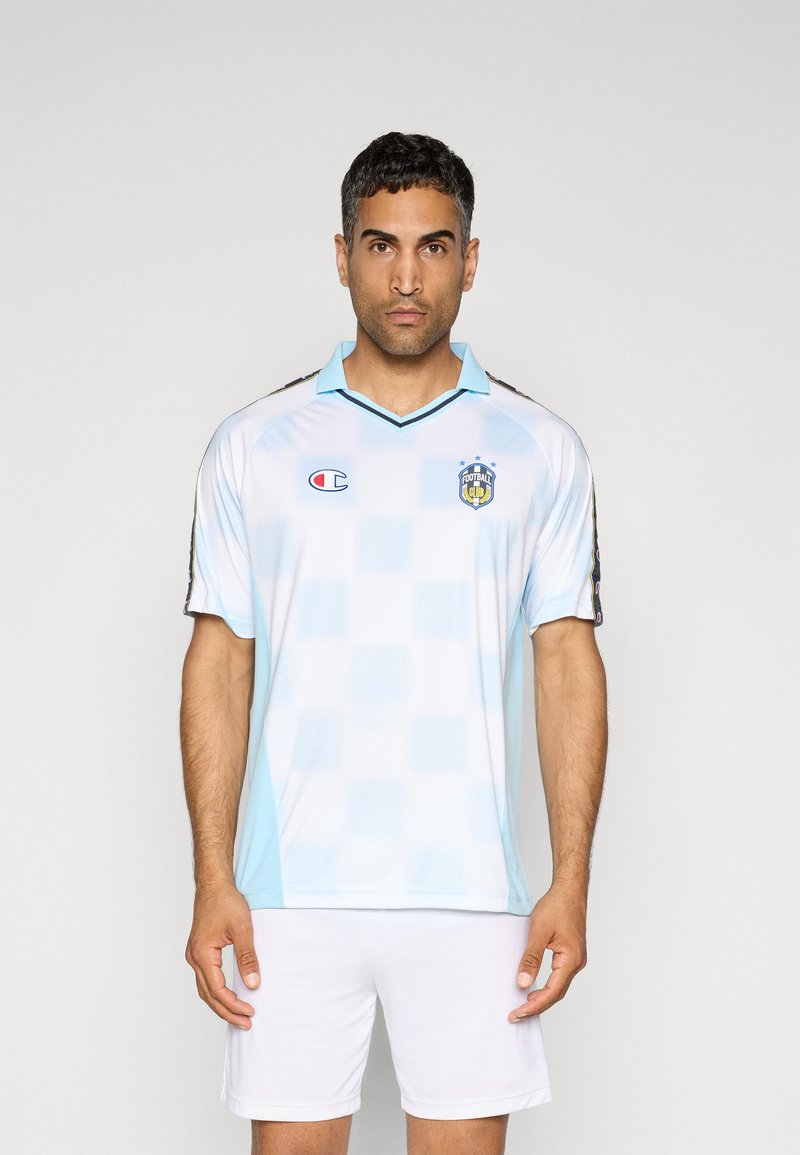 Lichtblauw voetbalshirt met een geruit patroon, zwarte accenten, kraag en Champion-logo. Draagt samen met witte shorts. Korte mouwen.