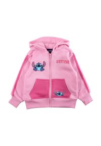 Sweat à capuche rose en tissu doux, doté d'une fermeture éclair à l'avant, de deux poches, et de motifs du personnage Stitch sur la poitrine et les poches.