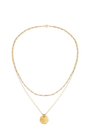 Dwa złote naszyjniki, jeden z teksturowanym okrągłym wisiorkiem, ułożone warstwowo na białym tle.