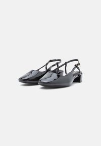 Μαύρα λουστρίνι slingback παπούτσια με χαμηλό τακούνι μπλοκ, σχέδιο σε μυτερή μύτη και ρυθμιζόμενους ιμάντες στον αστράγαλο. Λείος, γυαλιστερός υφής.