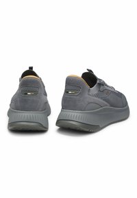 Gray athletic shoes with suede and mesh materials, featuring a textured midsole, reinforced heel, and contrast accents on the back.