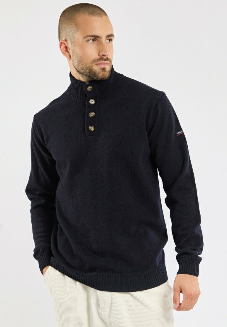 Pull en maille bleu marine avec un col haut, présentant une patte de boutonnage et des poignets et un ourlet côtelés. Texture lisse avec des coutures visibles.