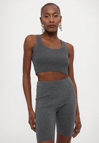 Sivý rebrovaný crop top a vysoké šortky z mäkkej, elastickej látky. Má výstrih do oválu a minimálne švy pre hladký vzhľad.
