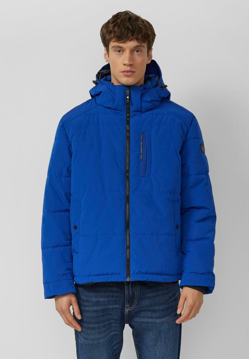 Niebieska kurtka puchowa z wysokim kołnierzem, przednim zamkiem błyskawicznym i bocznymi kieszeniami. Posiada pikowany wzór i naszywkę z logo na rękawie.