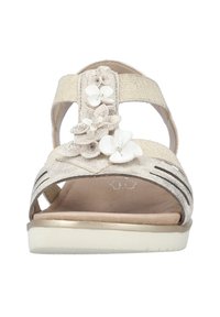Ljusguld sandaler med tygremmar, blomsterdekorationer i vitt, öppen tå, låg klack, texturerad innersula och dekorativa utskärningar.