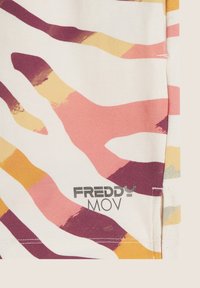 La maglietta Freddy MOV in morbido tessuto presenta una base bianca con motivi astratti di onde rosa, viola e gialle. Include un dettaglio del logo.