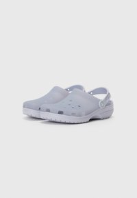 Light purple clogs made of flexible material with ventilation holes and a heel strap. Features a white outsole with patterned texture.