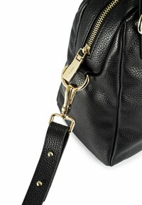 Rogaty czarny torebka ze skóry o strukturze kamieni, z złotym suwakem, złotymi zapięciami i przymocowanym czarnym skórzanym paskiem z złotymi ćwiekami.