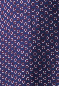 Tessuto navy con un motivo di piccoli cerchi concentrici rossi e blu. Texture liscia, design uniformemente spaziato, adatto a vari utilizzi per abbigliamento.