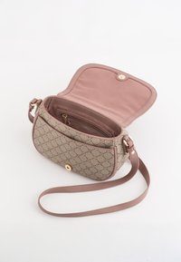 Béžová crossbody taška se vzorem a růžovou podšívkou, s kovovou patentkou ve zlatém tónu a odnímatelným ramenním popruhem.