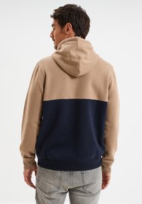 Felpa con cappuccio, parte superiore beige e parte inferiore blu navy, in misto cotone, texture morbida, dettagli con polsini e vita a coste.
