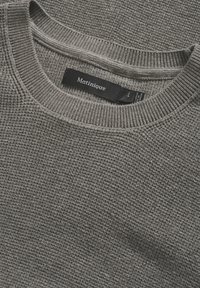 Szary sweter dziany z teksturowanym wzorem i ściągaczem przy okrągłym dekolcie. Wewnątrz kołnierza znajduje się czarna metka z napisem "Matinique" oraz rozmiarem "L".