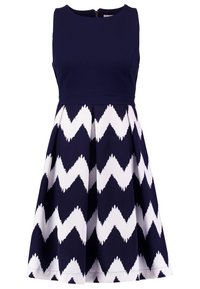 Marinblå ärmlös klänning med en figursydd överdel och en utsvängd kjol som har ett vitt zigzag-mönster, tillverkad av ett slätt tyg.