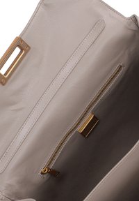 Interno di una borsa in pelle grigia chiara con una tasca con cerniera dorata, texture liscia e un accento in hardware dorato rettangolare.