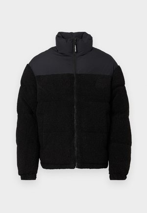 Fekete pufi dzseki magas gallérral, puha, textúrált fleece anyagú testtel, sima, matt szövet a vállakon és a galléron.