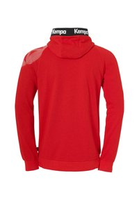 Sweat à capuche rouge avec cordons, présentant un col noir avec une marque et un motif en mesh sur l'épaule droite. Manches longues et ourlet droit.