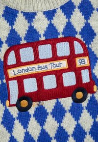 Sarkans izšūts Londones autobusa dizains uz zila un balta dimanta raksta auduma. Iespējas ietver riteņus, logus un tekstu "Londones autobusa tūre".
