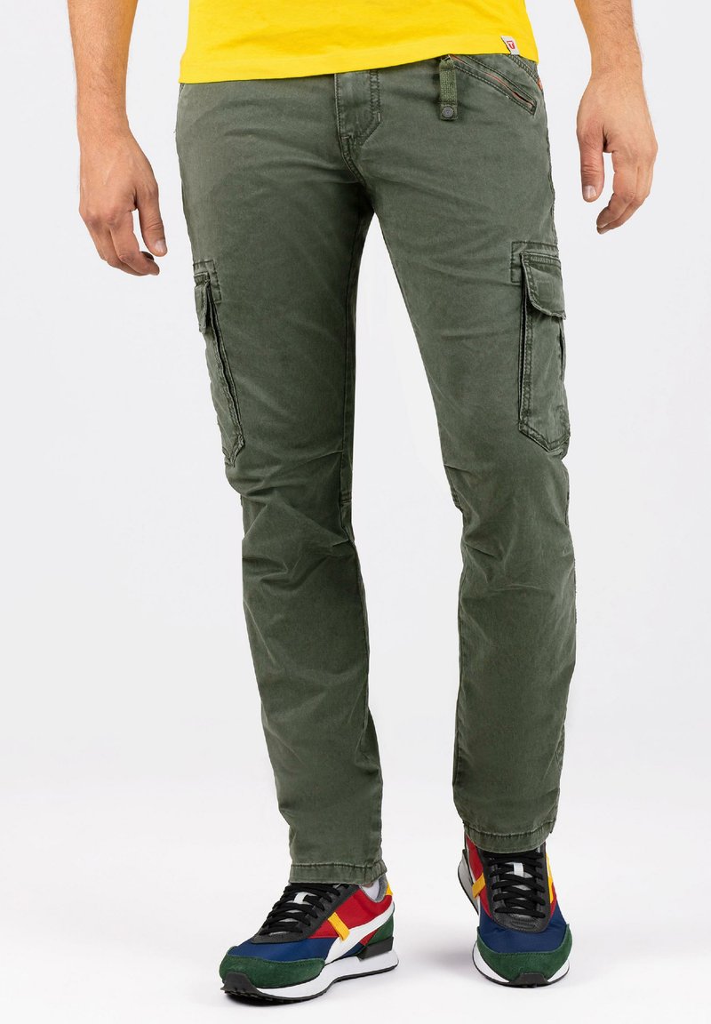 Olijfgroene katoenen cargobroek, voorzien van zijzakken, een slim fit en contrasterende stiksels. Gecombineerd met meerkleurige sportieve sneakers.