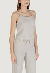 Top senza maniche grigio chiaro con spalline sottili, caratterizzato da una vestibilità comoda e una consistenza morbida. Abbinato a pantaloni ampi con vita elastica.