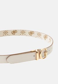 Beige leather belt with gold hardware, featuring a prominent 'G' logo and a patterned inner lining with gold accents on a light background.