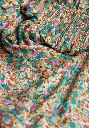 Blumenmusterstoff mit kleinen, bunten Blumen in Rosa, Türkis und Orange auf einem beigen Hintergrund; geraffte Textur.