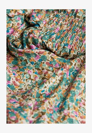 Tissu à motif floral avec de petites fleurs colorées dans des teintes de rose, turquoise et orange sur un fond beige ; texture froncée.