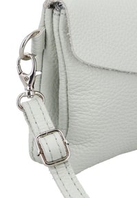 Šviesiai pilka odinė rankinė su tekstūruota paviršiaus, dengiamuoju flapu, metaliniais elementais ir reguliuojamu dirželiu su siuvimo detalėmis.