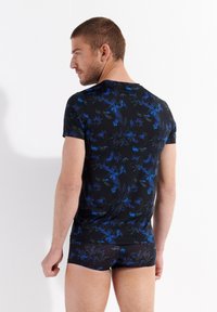 Black fitted shirt and shorts set with blue floral pattern, made of stretchy material, short sleeves, and a smooth texture.